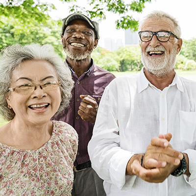Three elderly friend outside laughing together
